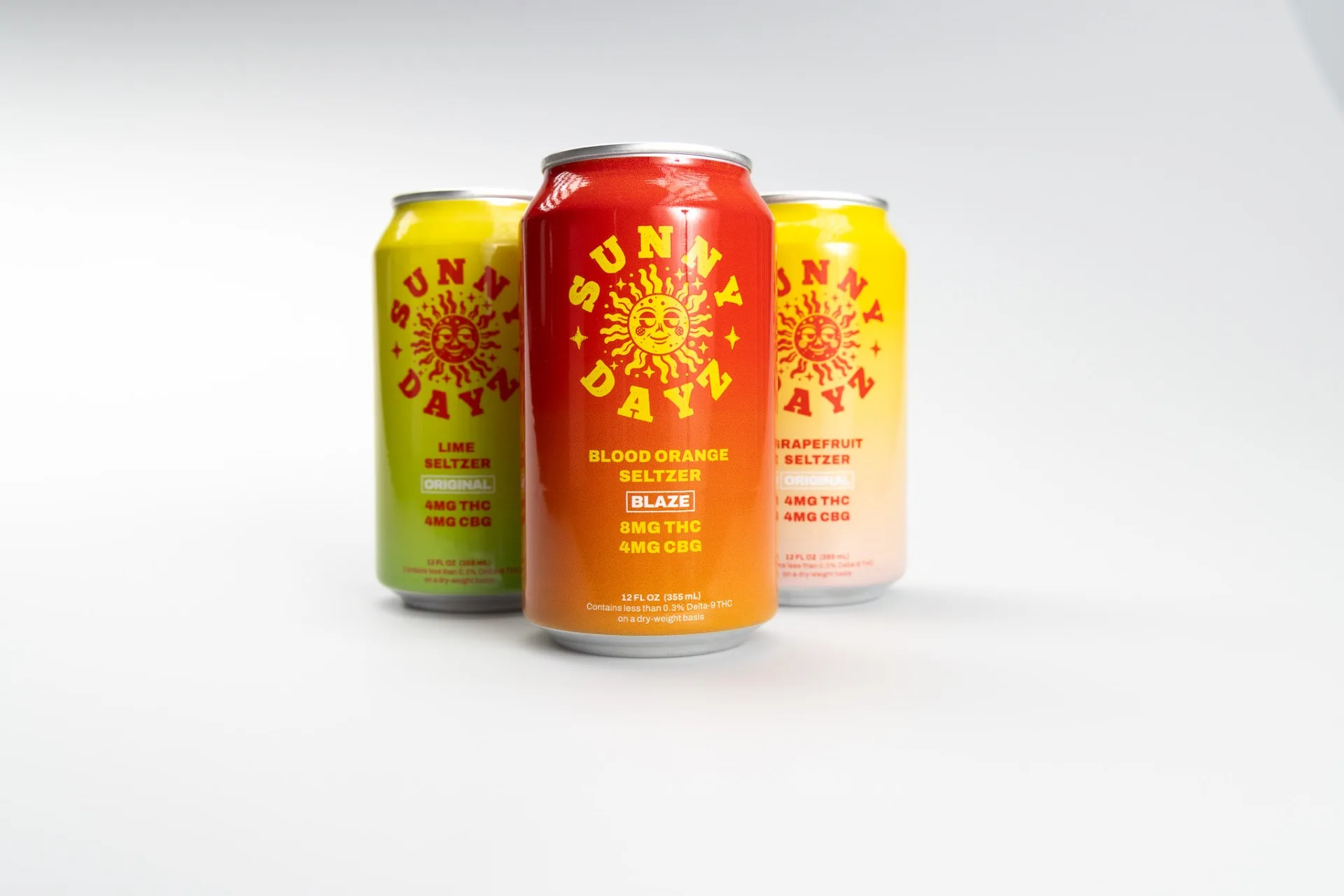 Three Sunny Dayz hemp-derived THC seltzer cans on a white background: lime and grapefruit at 4mg THC and 4mg CBG, and blood orange Blaze at 8mg THC and 4mg CBG.